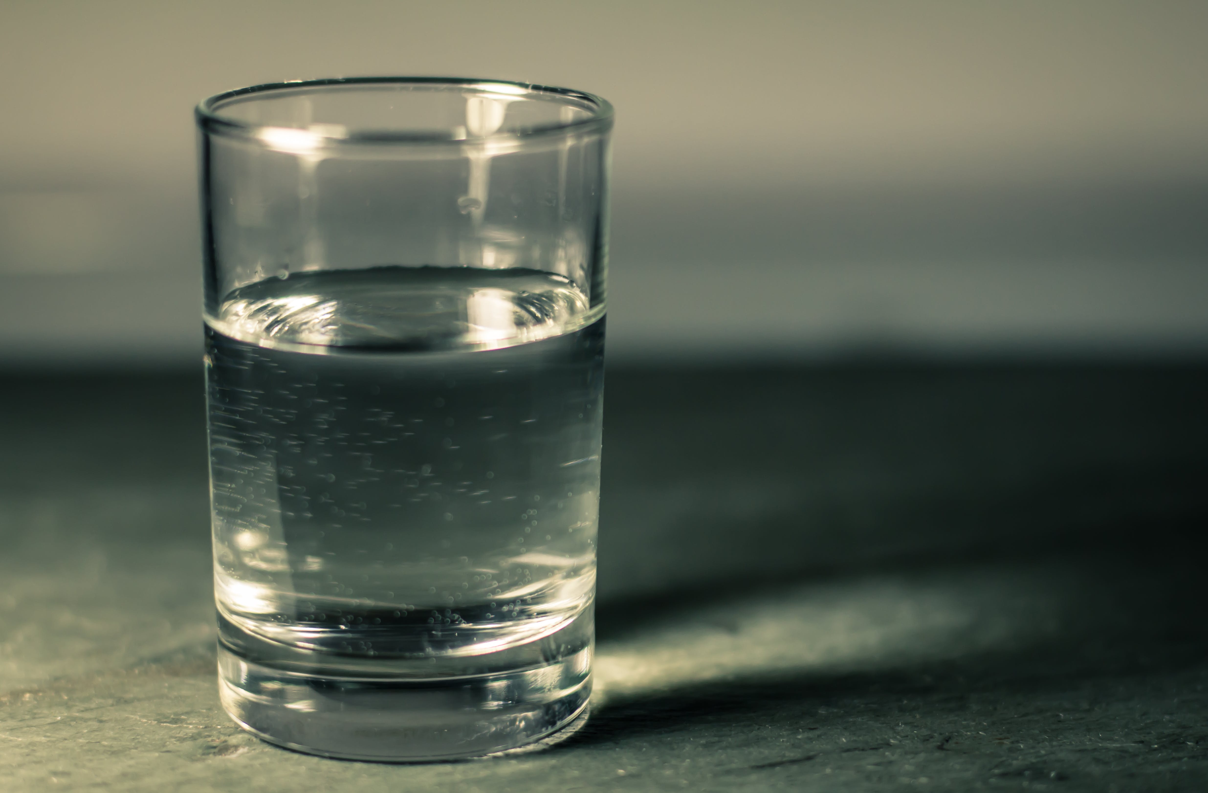 На столе пустой стакан. Стакан воды. Полстакана воды. Стакан воды наполовину. Стаканы для воды стеклянные.