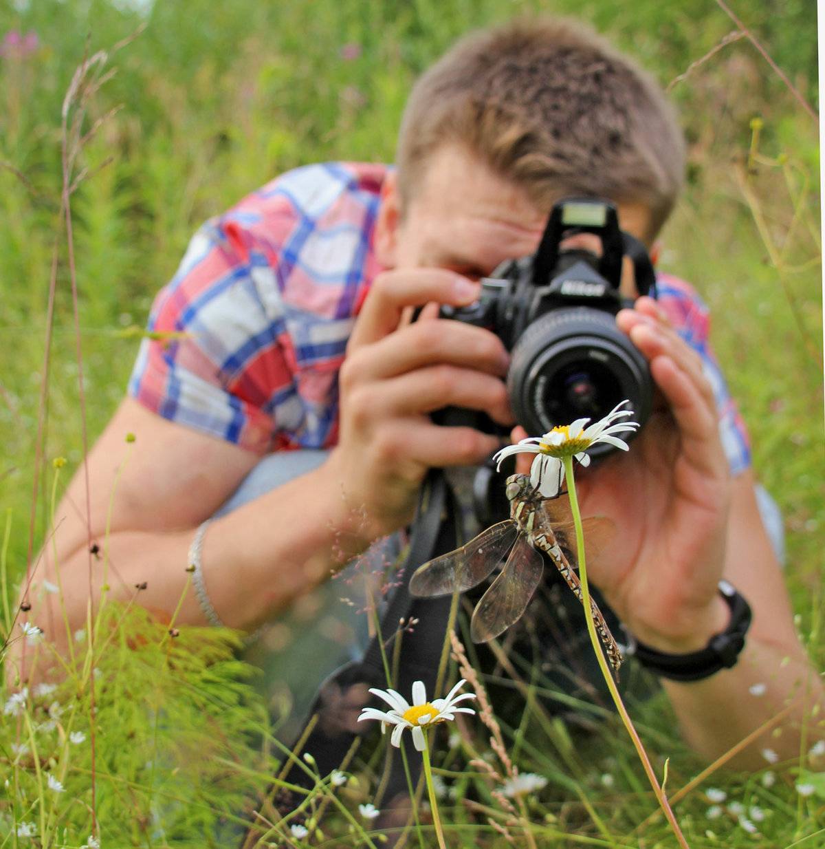 Сайт фотоконкурсов. Фотограф с фотоаппаратом. Человек с фотоаппаратом на природе. Фотограф с камерой. Фотограф фотографирует.