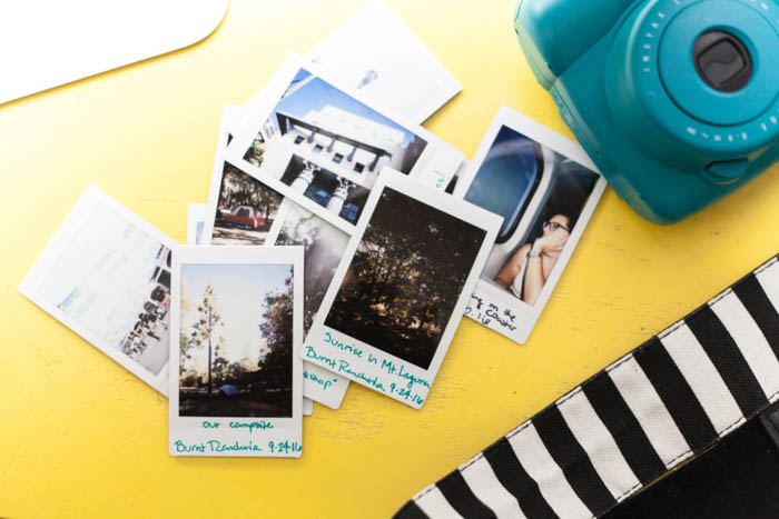 instant photographs on a yellow background next to a Fujifilm Instax Mini 