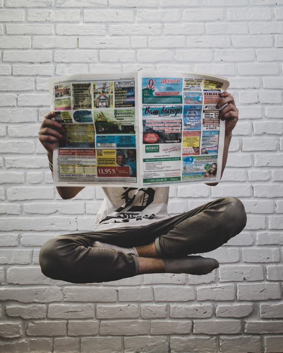 A man levitating and reading a newspaper for professional photography