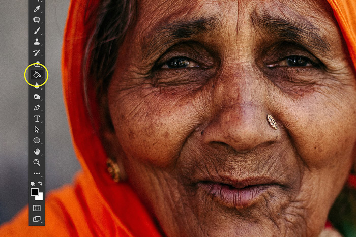 A screenshot showing how to sharpen an image in Photoshop using a portrait of an Indian woman