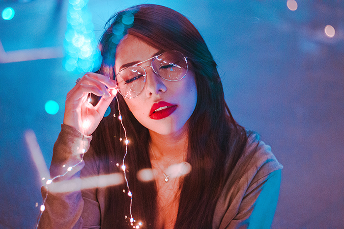 Atmospheric portrait of a female model holding fairy lights shot using neon photography