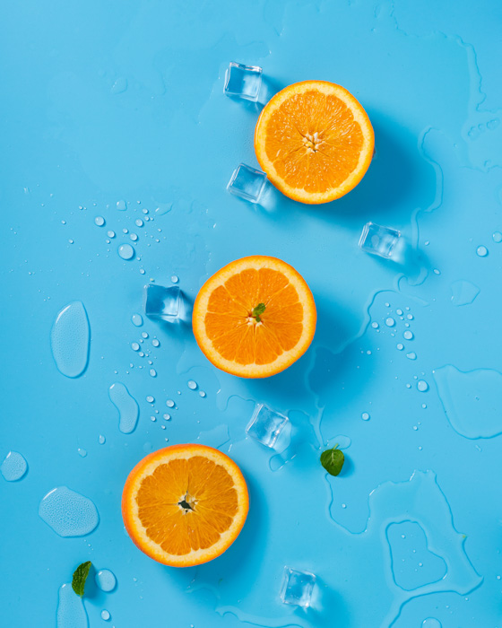 Three orange halves sit on a blue background - complementary colors
