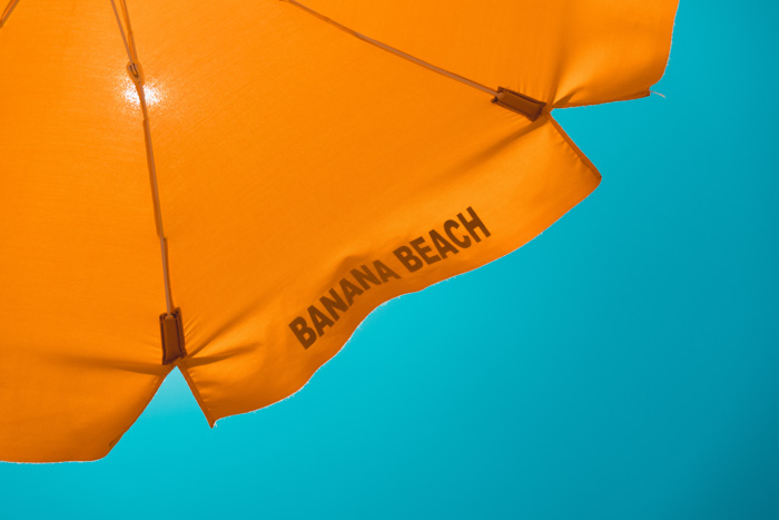 An orange parasol sits in front of a inviting blue sky - complementary colors