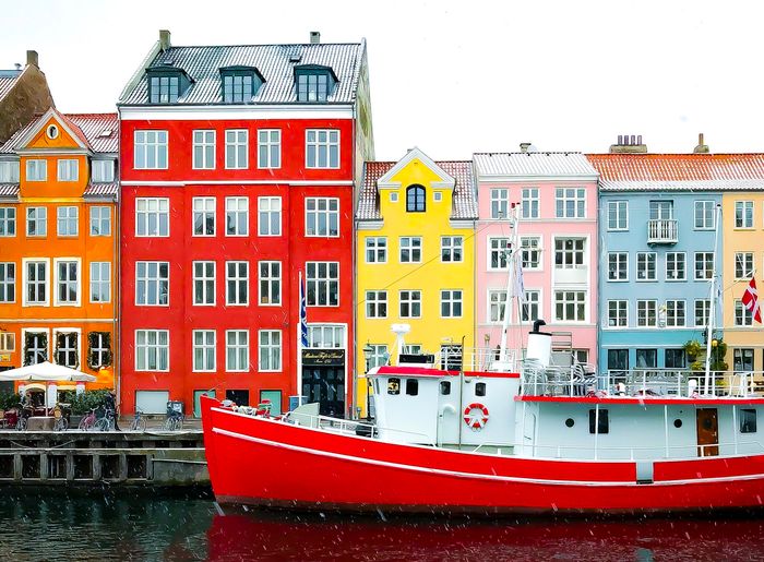 Photo of a ship with colorful houses in the background