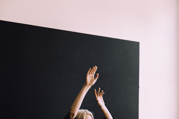 A woman posing with hands in the air