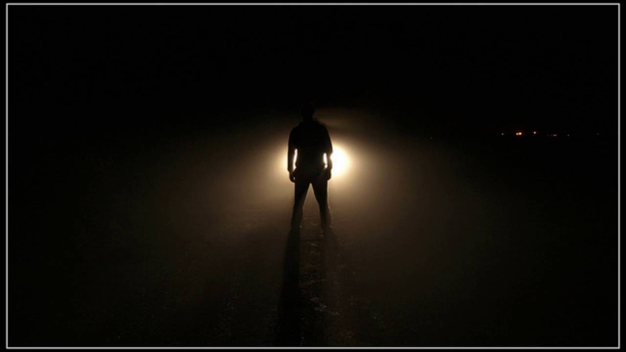 Тем кто видел тьму. Человек с фонариком в темноте. Человек на дороге ночью. Человек в свете фар. Парень во тьме.