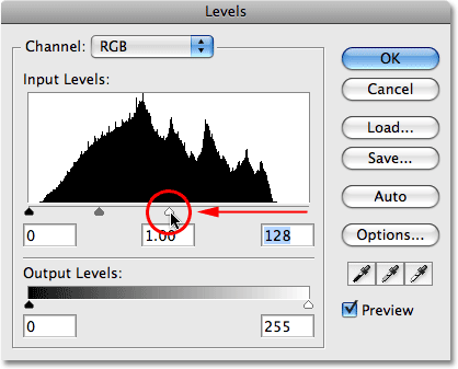 Dragging the white point slider to the middle of the histogram. Image © 2009 Photoshop Essentials.com.