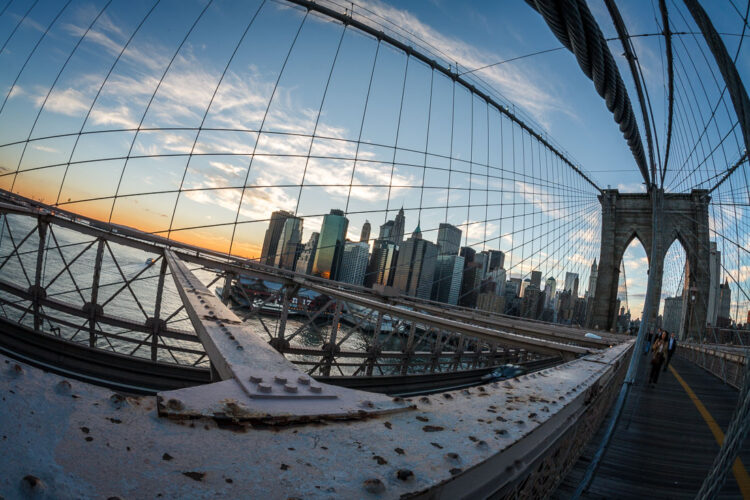 a wide angle lens makes this photo of new york city bridge look distorted and the city smaller
