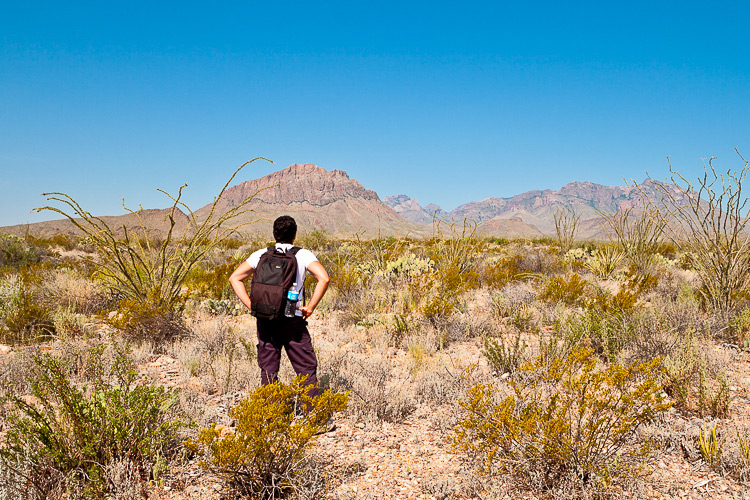 man with backpack in the barren desert - beginner photographer tips